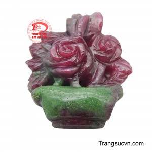 Sắc đỏ nồng nàn của ruby hòa quyện cùng màu xanh lục của lá và chậu cây, tạo nên một tổng thể hài hòa và lãng mạn.