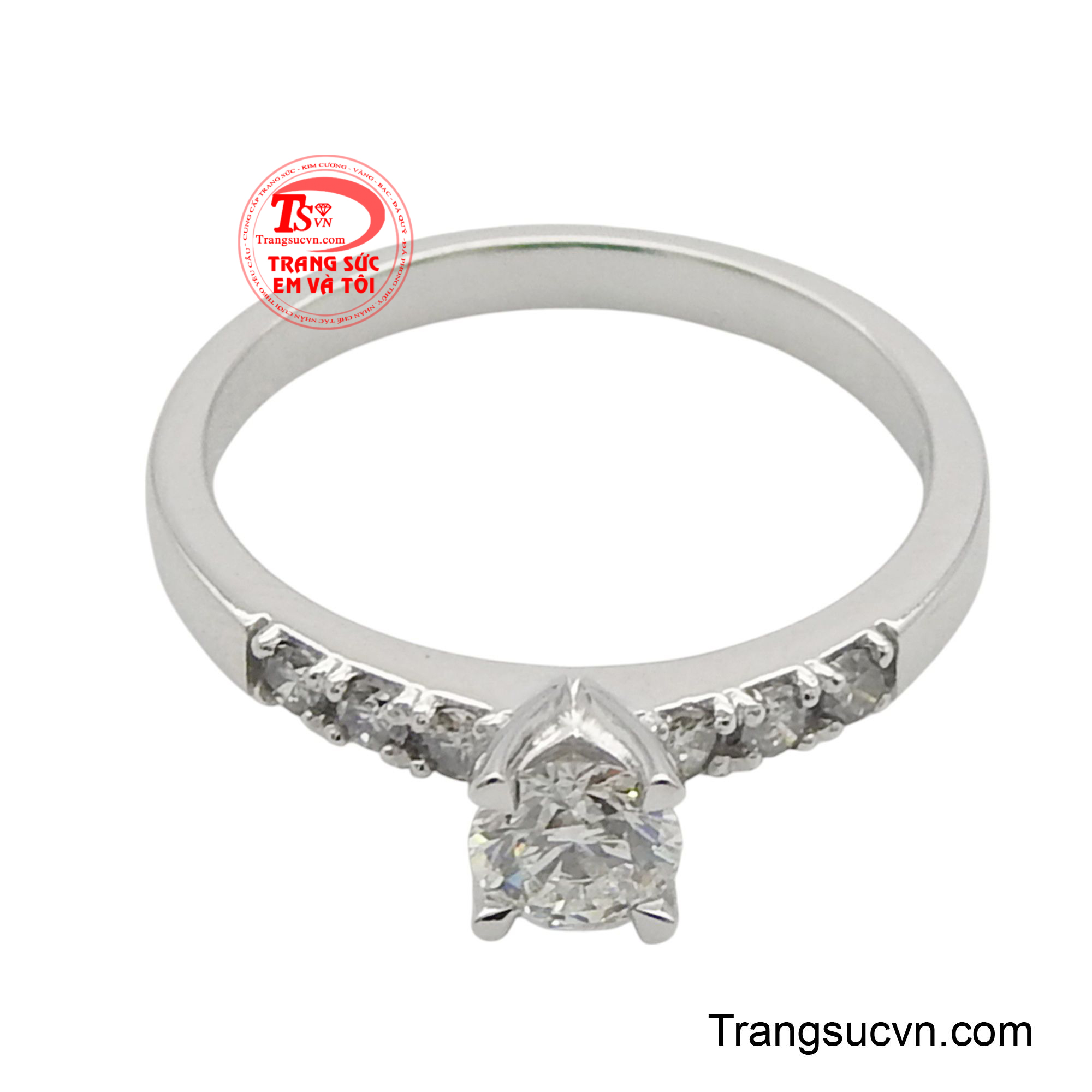 Hai bên viên kim cương chủ là những hàng kim cương tấm nhỏ hơn, được đính kết tỉ mỉ trên thân nhẫn, tạo nên một dải ánh sáng không ngừng nghỉ, làm tăng thêm sự quyến rũ và lấp lánh cho tổng thể.