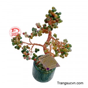 Thân cây được uốn lượn khéo léo từ những sợi kim loại, vững chãi vươn lên từ chậu gốm xanh thẳm, tượng trưng cho sự sinh sôi và phát triển.