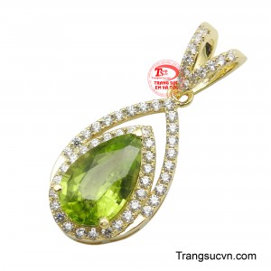 Viên đá Peridot hình giọt nước ở trung tâm, với sắc xanh lục tươi mát và trong trẻo như ánh nắng ban mai, thu hút mọi ánh nhìn.