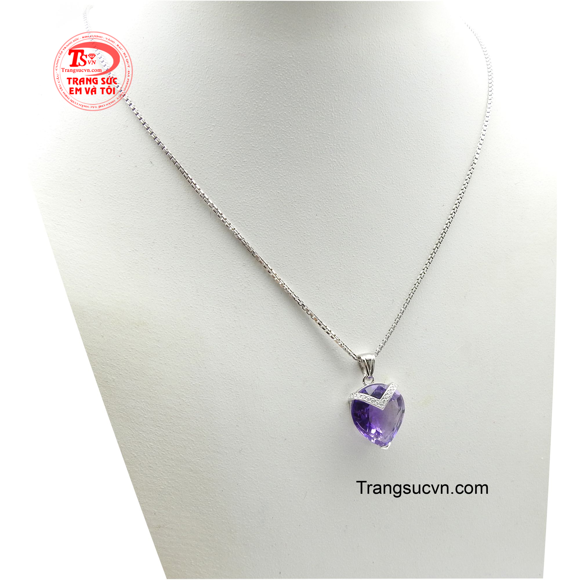 Tâm điểm là viên Thạch Anh Tím lớn, được cắt mài hình trái tim tinh xảo, phô bày sắc tím hoàng gia sâu thẳm, tượng trưng cho tình yêu chân thành và sự thông thái.