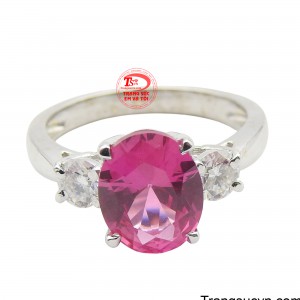 Tâm điểm là viên đá chủ hình bầu dục với sắc hồng đậm hoặc đỏ thẫm rực rỡ, được cố định bằng các chấu chắc chắn, tạo hiệu ứng lộng lẫy và quyến rũ.