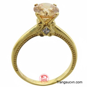 Điểm nhấn tinh xảo là chi tiết hạt đá vuông nhỏ được đính kèm ở hai bên viên chủ, cùng với họa tiết chạm bi dọc theo đai nhẫn, tăng thêm vẻ cầu kỳ và ấn tượng về mặt thị giác.