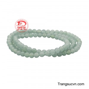 Mỗi viên ngọc được mài tròn đều, bề mặt bóng ánh như phủ một lớp sương mỏng, khẽ phản chiếu ánh sáng theo từng chuyển động nơi cổ tay. 