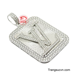 Điểm nhấn là biểu tượng chữ cái lớn có thể là logo hoặc tên viết tắt của chủ nhân được nạm bởi những viên đá Moissanite trắng lấp lánh toàn bộ, bao quanh bởi một viền đá rực rỡ, tạo nên sự sang trọng và ấn tượng khó quên.