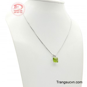 Viên peridot xanh trong được cắt theo kiểu bậc thang cân xứng, những mặt cắt song song mềm mại dẫn ánh sáng lan tỏa chậm rãi