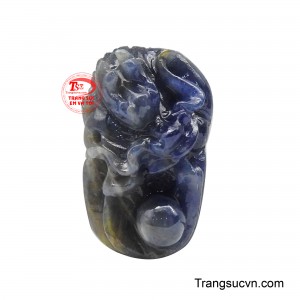 Mặt dây rồng bảo hộ được tạo tác từ viên sapphire thiên nhiên mang sắc xanh trầm sâu, màu đá gợi cảm giác vững chãi và an định. 