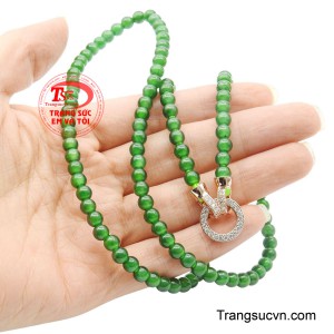 Chi tiết này không chỉ tạo sự tương phản hài hòa giữa ánh kim và sắc ngọc, mà còn mang ý nghĩa trọn vẹn, viên mãn như vòng tròn của hạnh phúc và thành công không ngừng nối tiếp.