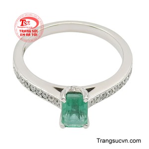 Hai bên đai nhẫn được điểm xuyết hàng đá nhỏ lấp lánh, tăng thêm độ sáng và làm nổi bật sắc xanh đặc trưng của emerald. 