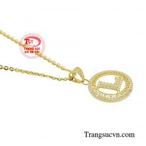 Chữ cái trung tâm được nạm đá trắng lấp lánh, bắt sáng rực rỡ ở mọi góc nhìn. 