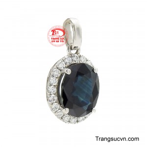 Tâm điểm của thiết kế là viên sapphire xanh lam được cắt giác oval tinh xảo, mang sắc xanh sâu thẳm đầy mê hoặc, đây là sắc màu thường được xem là biểu tượng của trí tuệ, sự cao quý và lòng trung thành. 