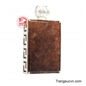 Tâm điểm của thiết kế là viên thạch anh tóc nâu bản lớn với những sợi tinh thể ánh kim đan xen tựa như những tia năng lượng đang chuyển động bên trong lòng đá. 