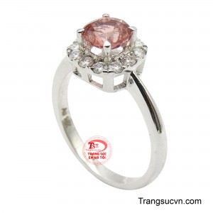 Mặt nhẫn nổi bật với viên Spinel thiên nhiên màu hồng phấn ấm áp, được cắt giác rực rỡ và đặt tại vị trí trung tâm. 