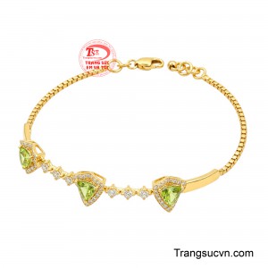 Thiết kế nổi bật với ba viên Peridot giác cắt hình tam giác được sắp xếp cân đối, tạo điểm nhấn cuốn hút trên cổ tay.